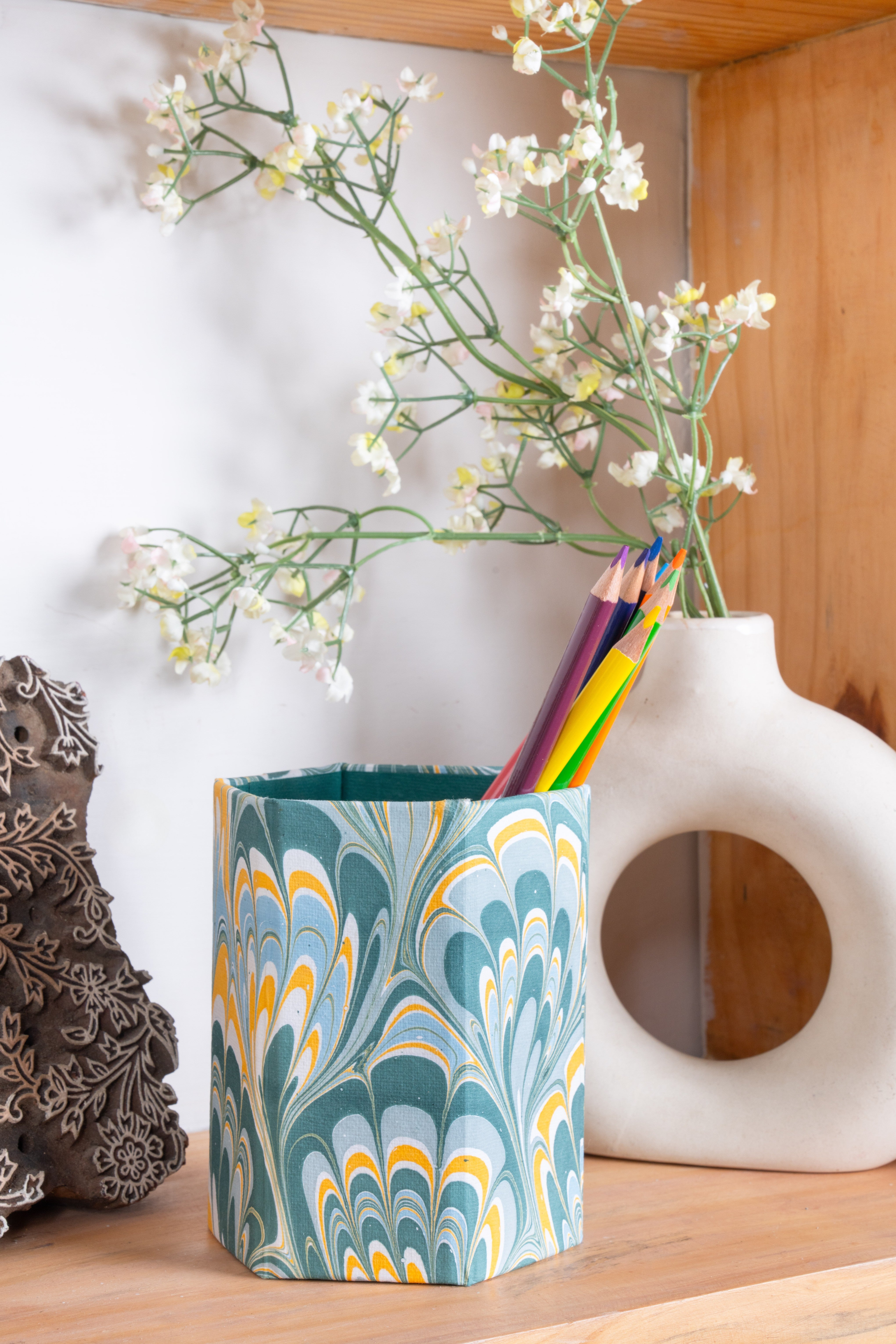 Hand-marbled pencil holder organizer in blue marbling with colored pencils on wooden shelf