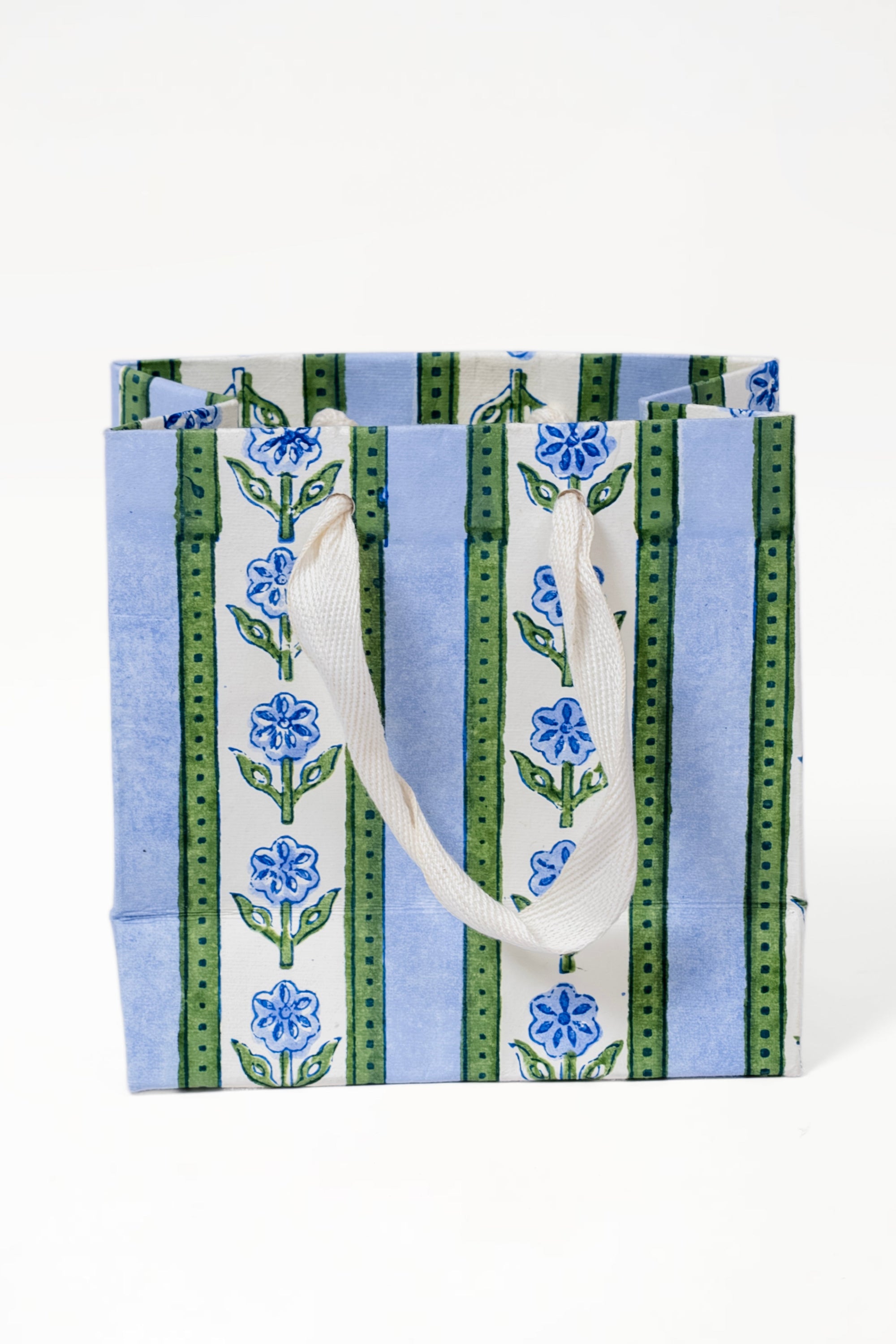 Small blue cottage garden blockprint gift bag with blue flowers, green stripes, and white handles