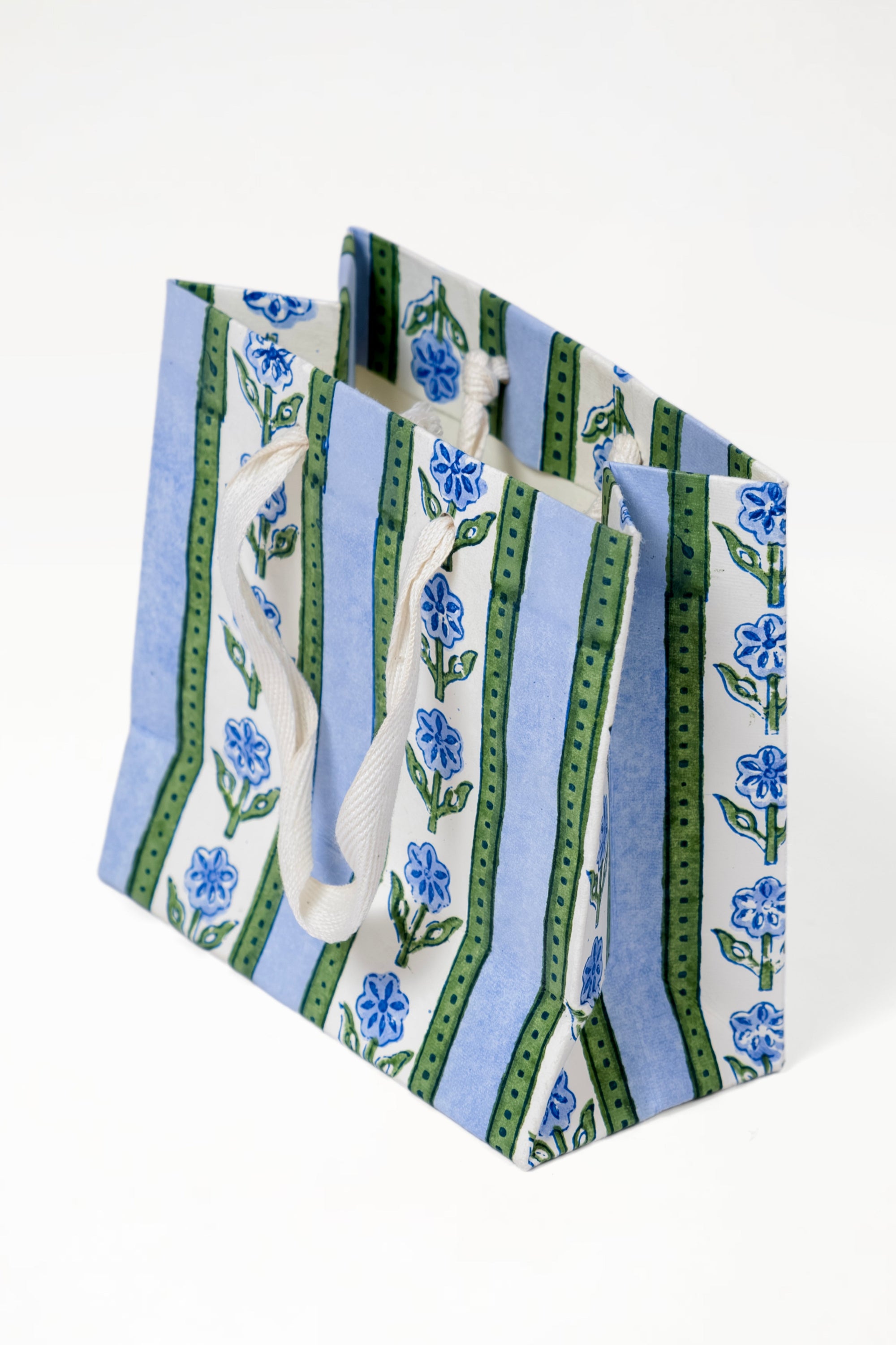 Blue cottage garden blockprint gift bag with blue flowers, green stripes, and white handles