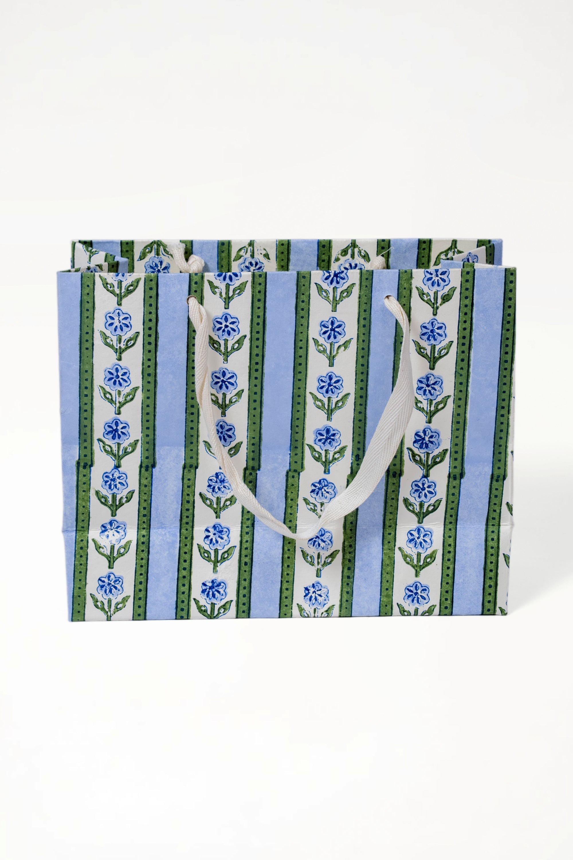 Medium blue cottage garden blockprint gift bag with blue flowers, green stripes, and white handles