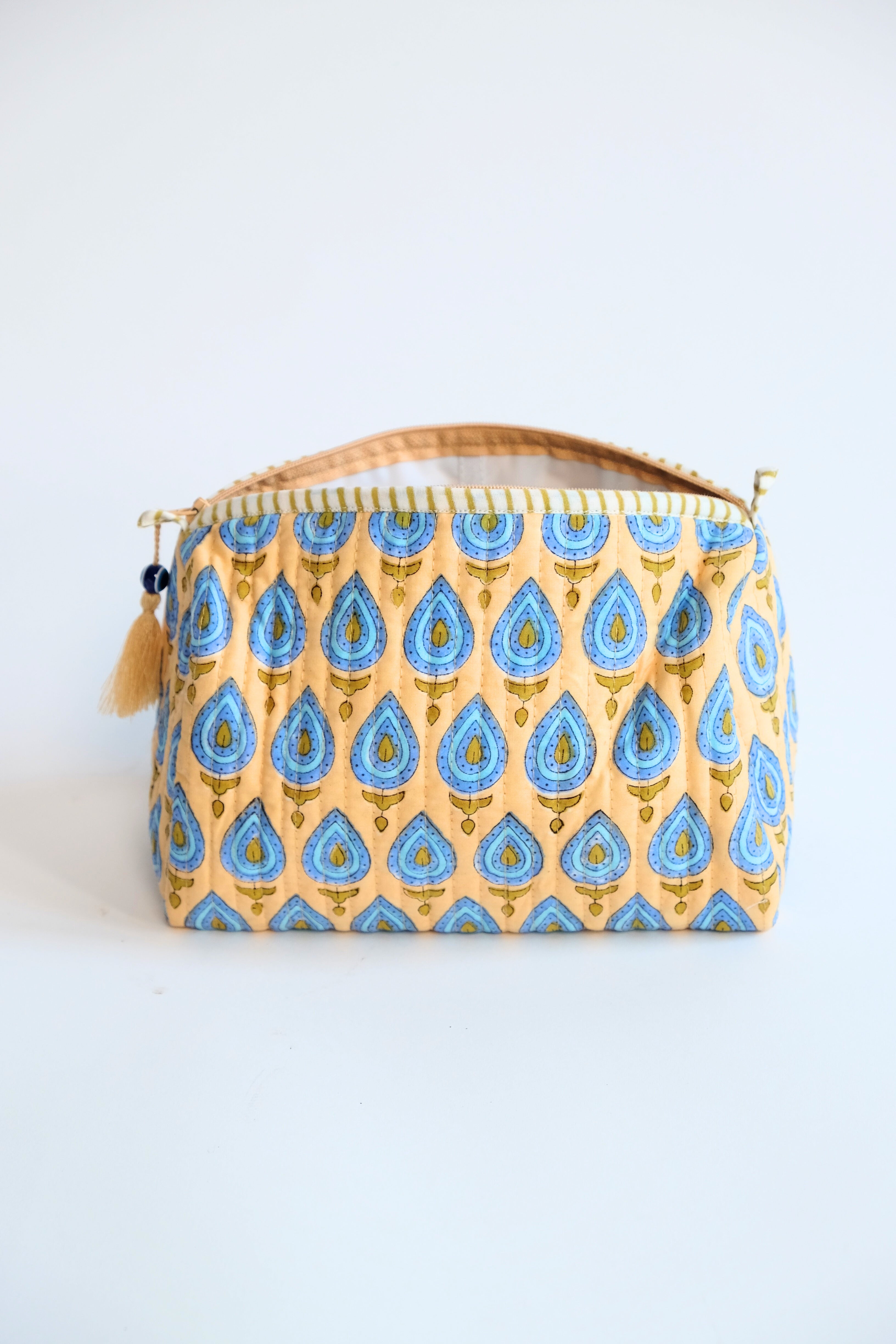 Front view of beige evil eye pattern toiletry bag with zipper handle - Inner Child