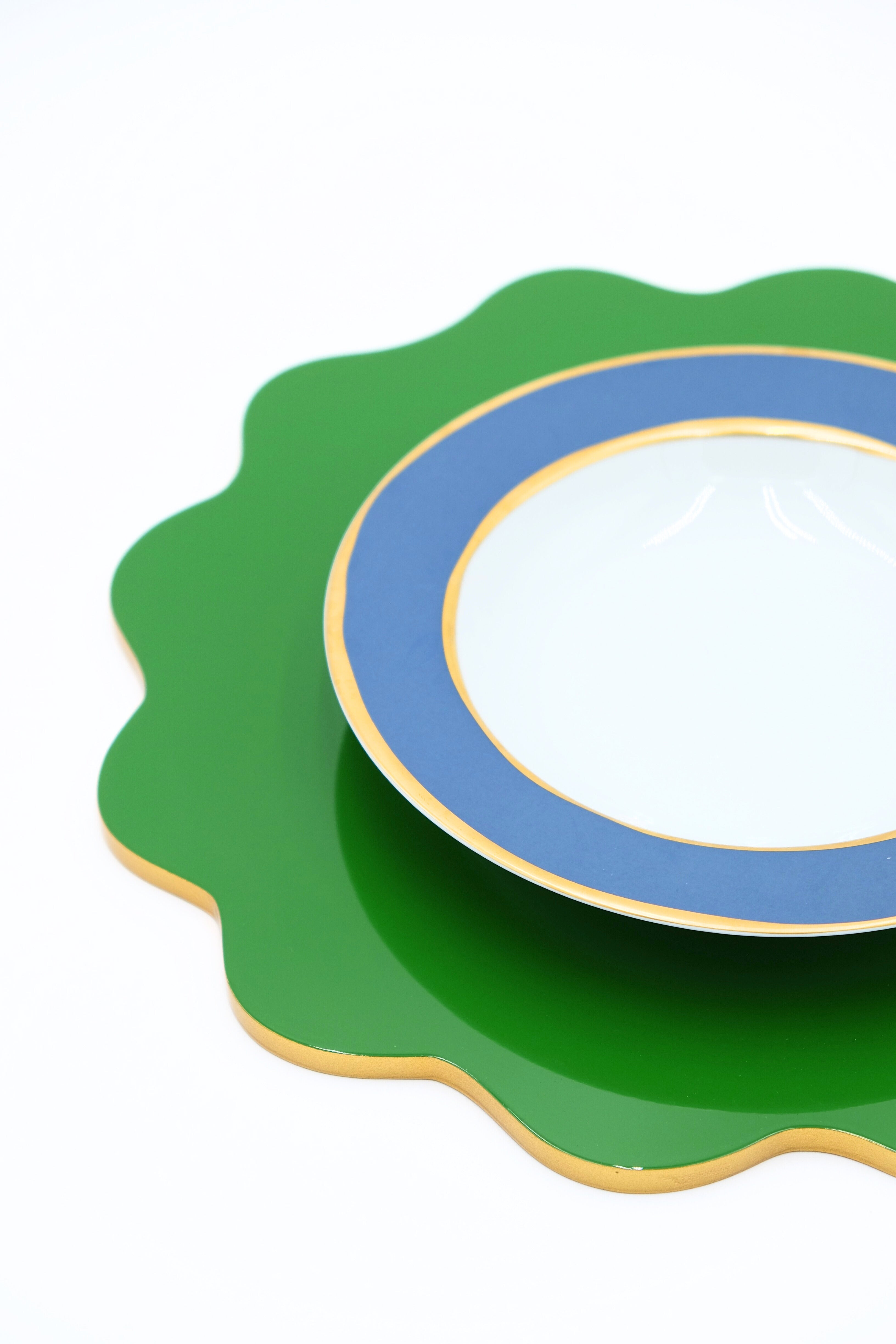Close-up of garden green scalloped lacquerware placemat with blue-rimmed plate from Inner Child