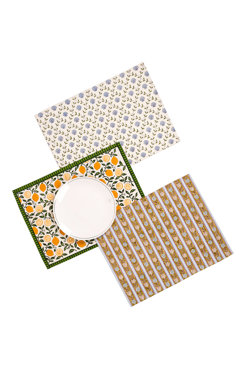 Assortment of placemats including blue floral, lemon, and gold stripe designs