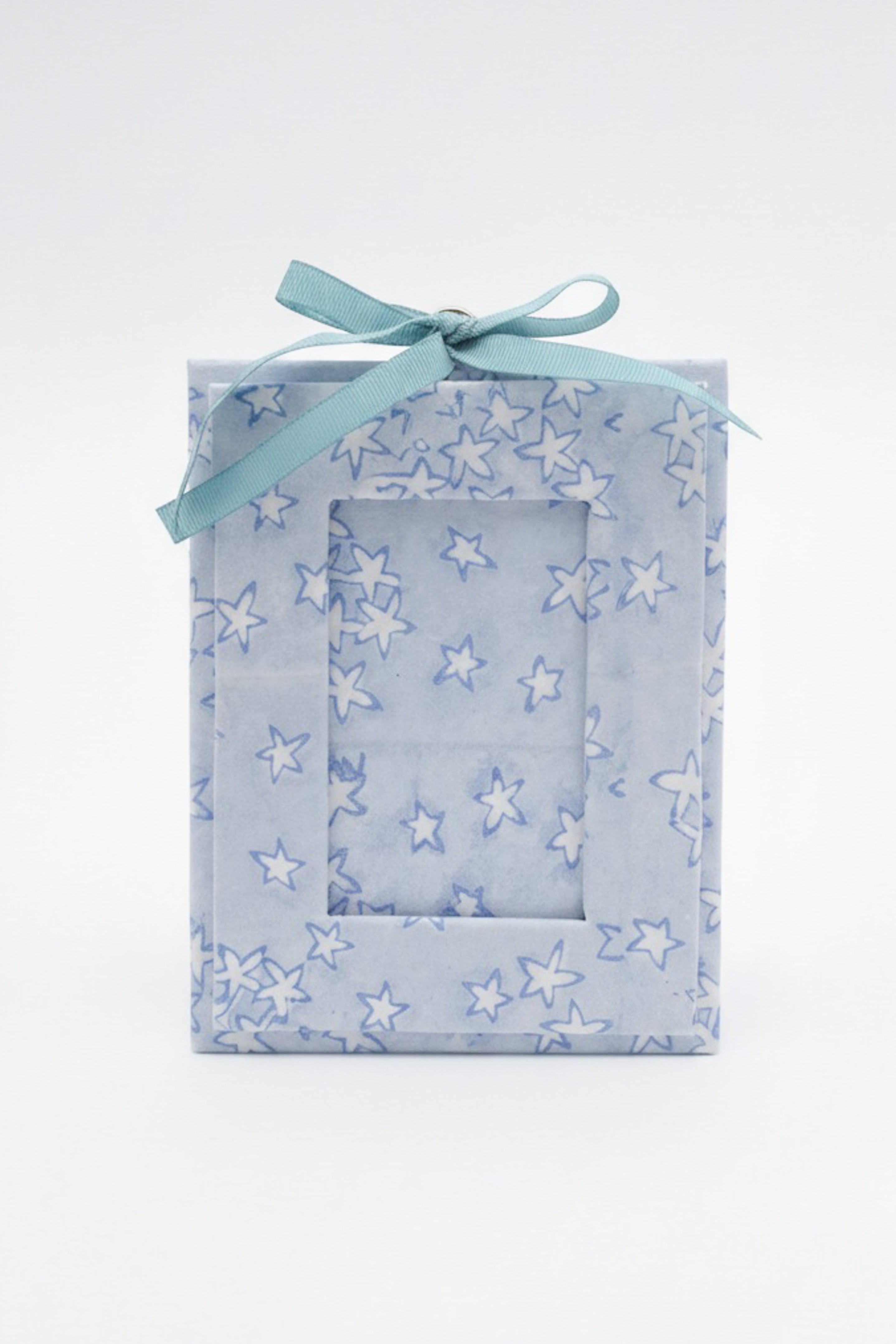 Blue star-patterned mini blockprint picture frame ornament with light ribbon on white background