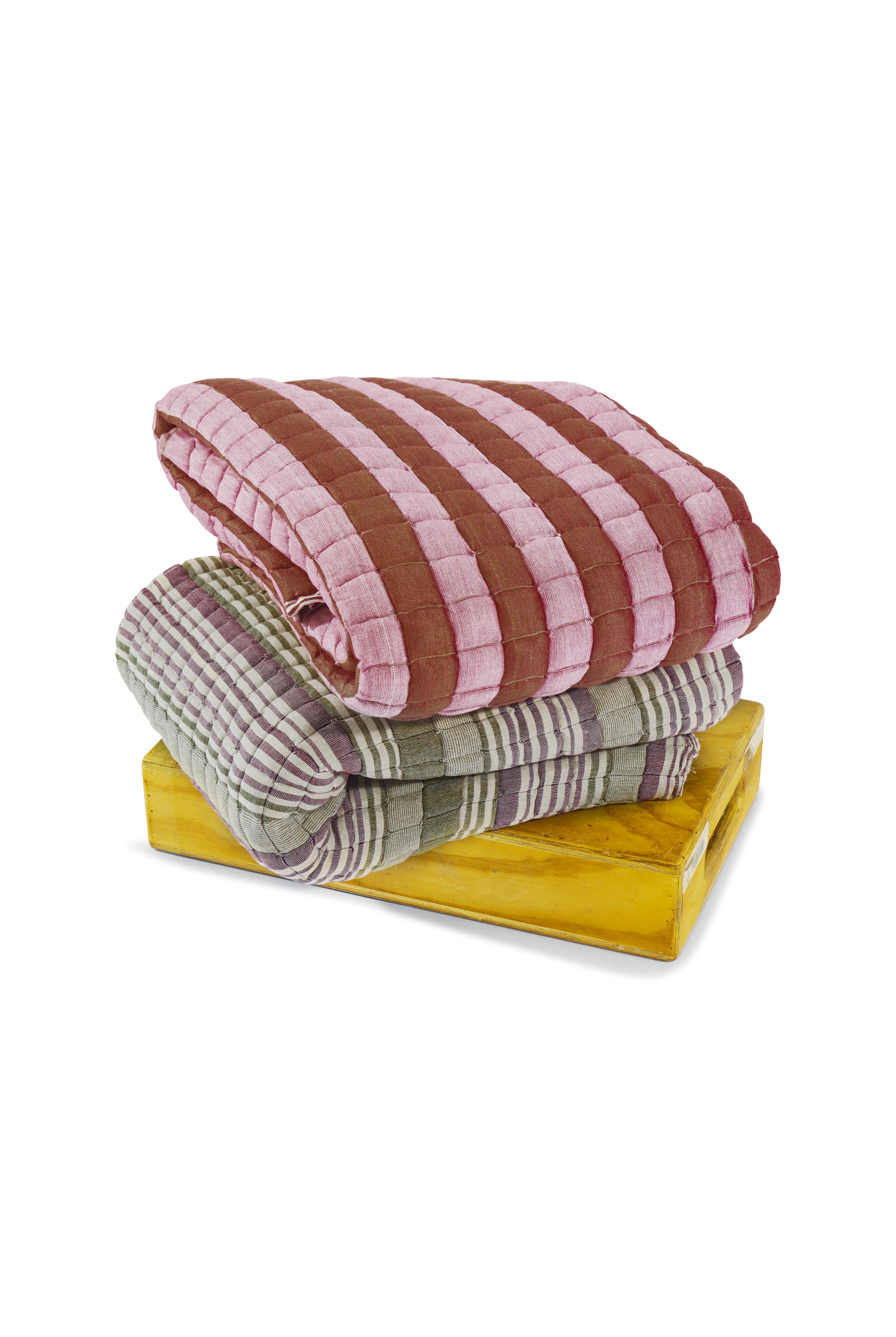 Sujani quilt stack with pink-brown stripes and green-purple stripes on yellow base