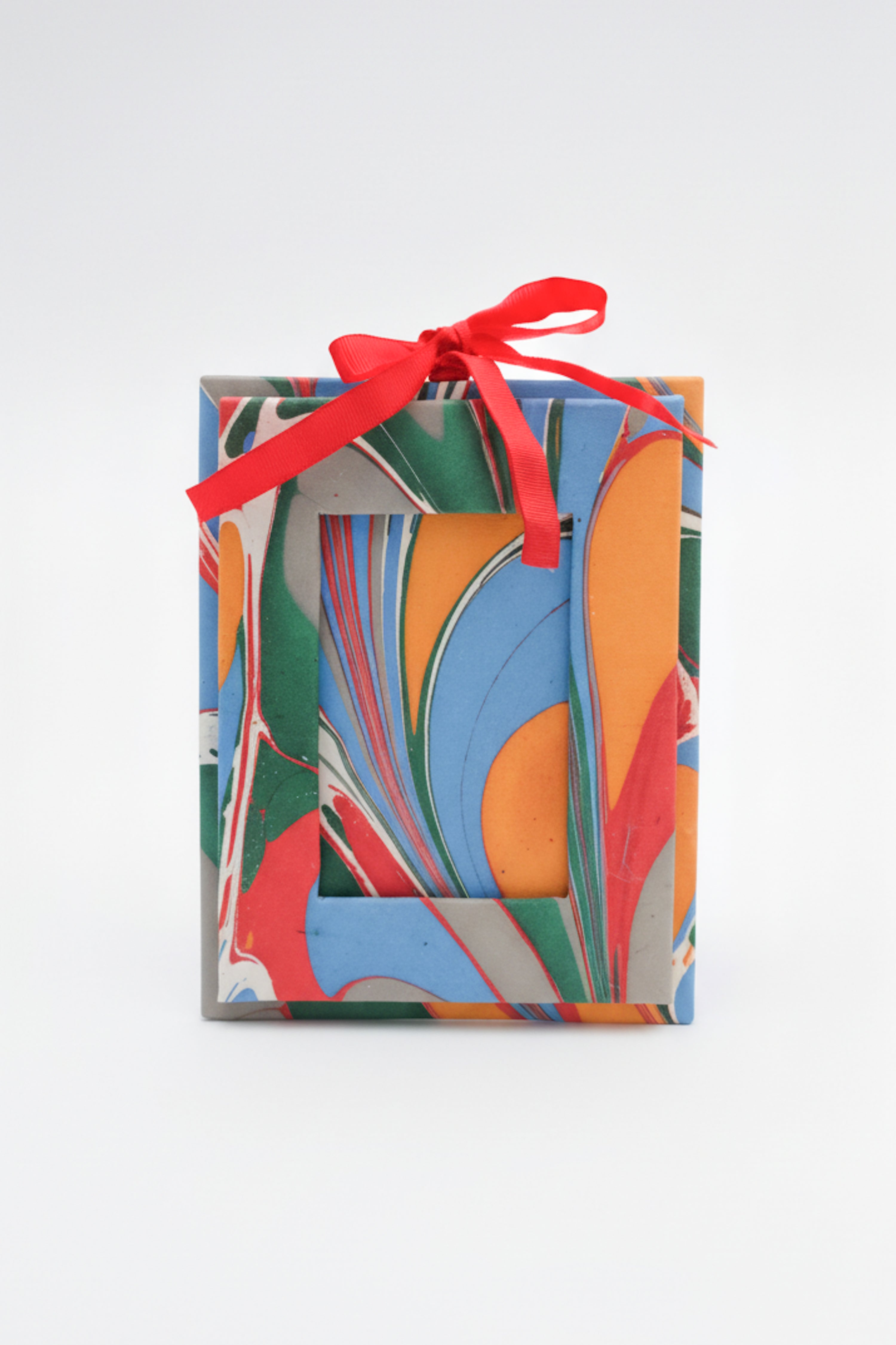 Vibrant hand-marbled mini picture frame ornament with red ribbon by Inner Child