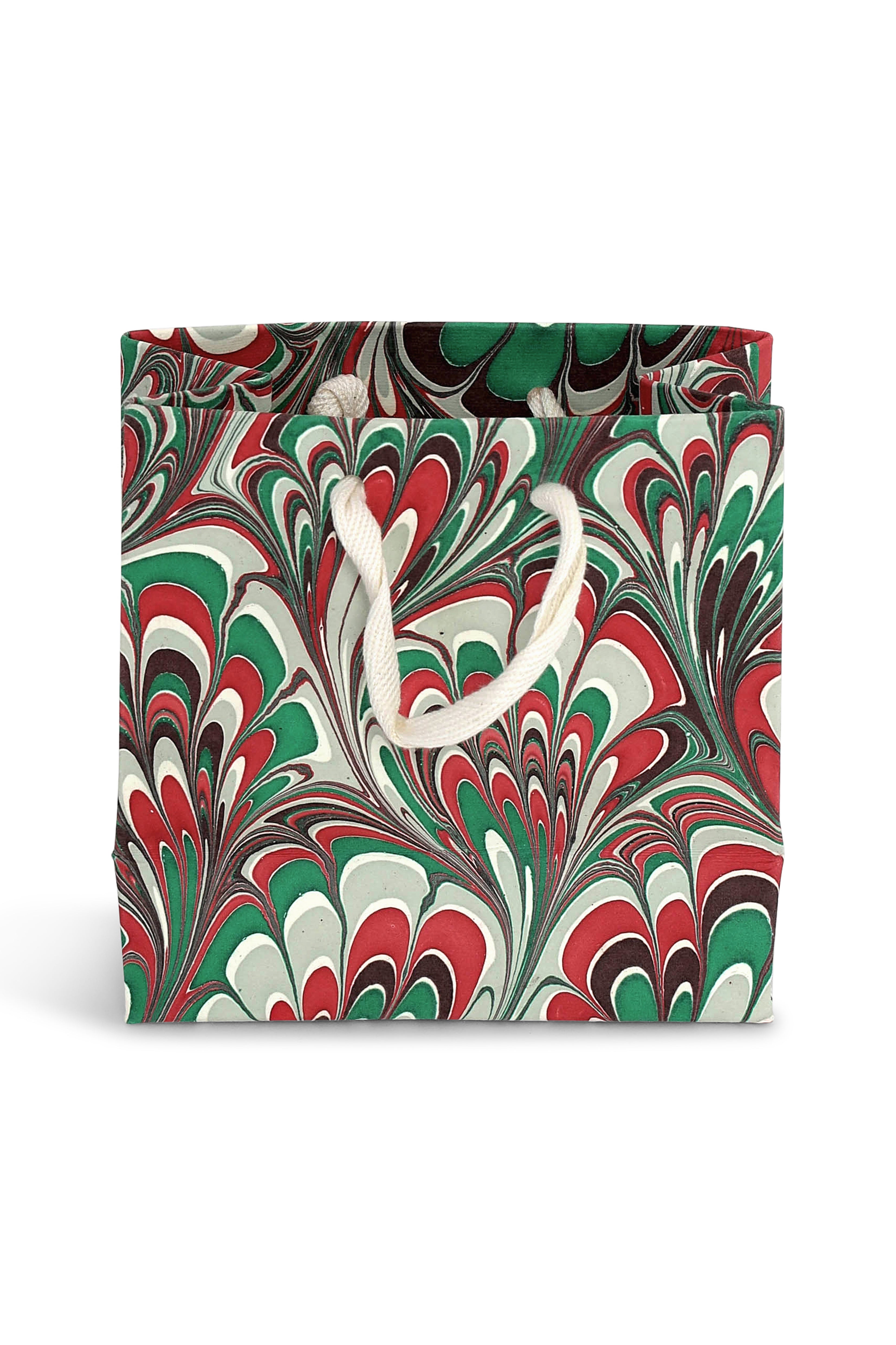 Small holiday festive hand-marbled gift bag with red, green, white swirling patterns