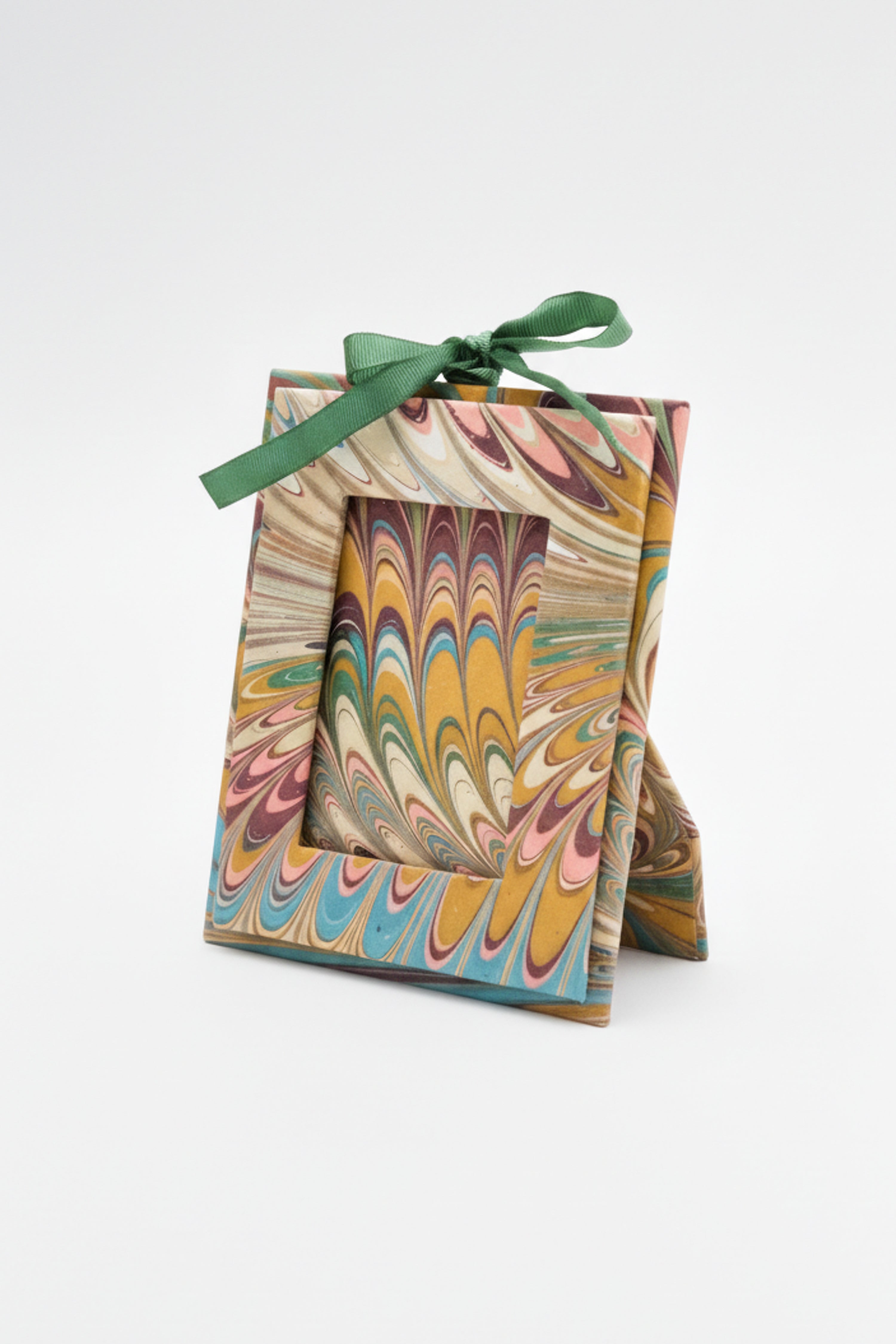 Mini hand-marbled picture frame ornament with green ribbon bow standing upright