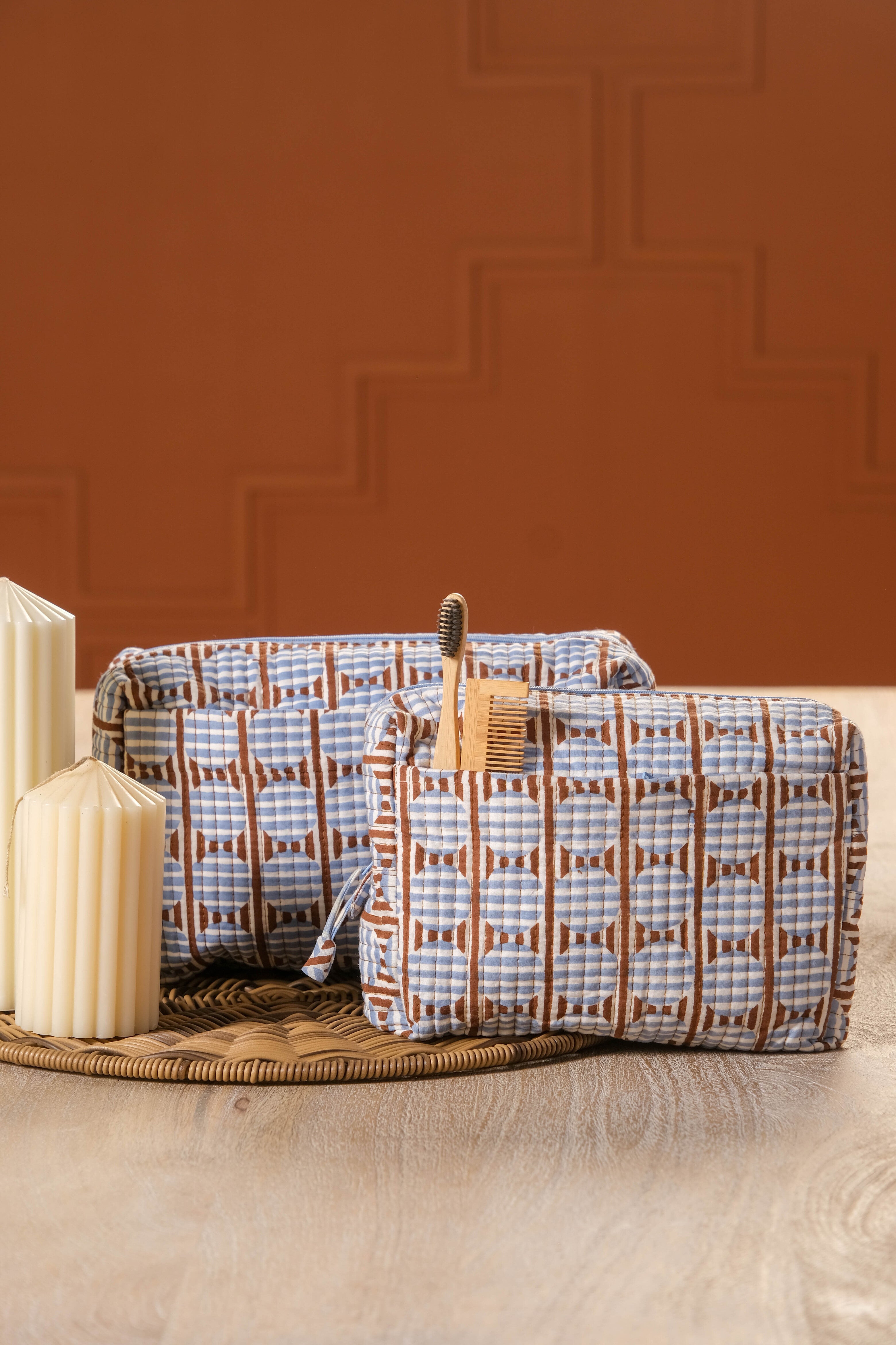Brown and blue striped circle blockprint travel pouches on woven mat with candles