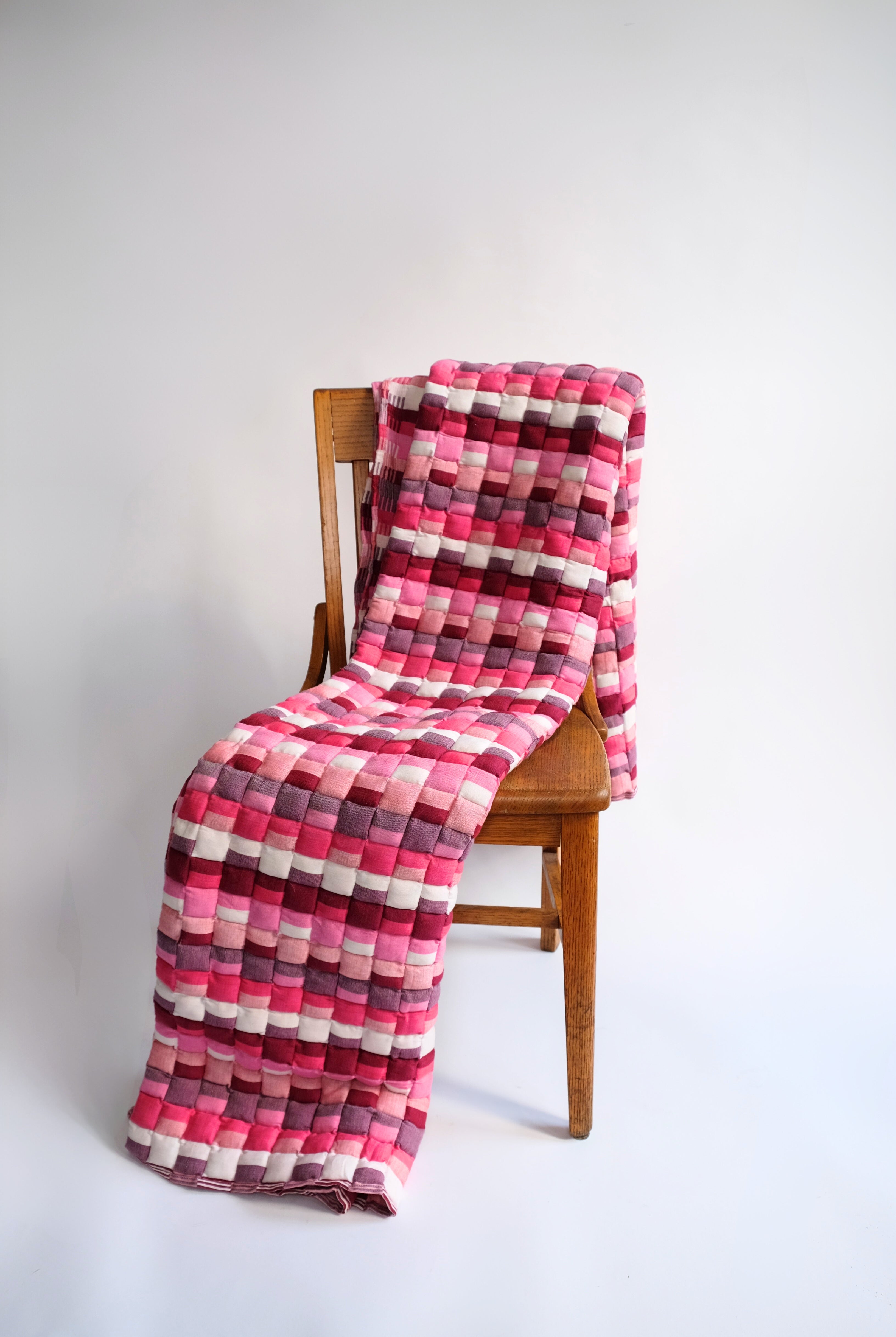 Pink Tetris Sujani quilt draped over wooden chair
