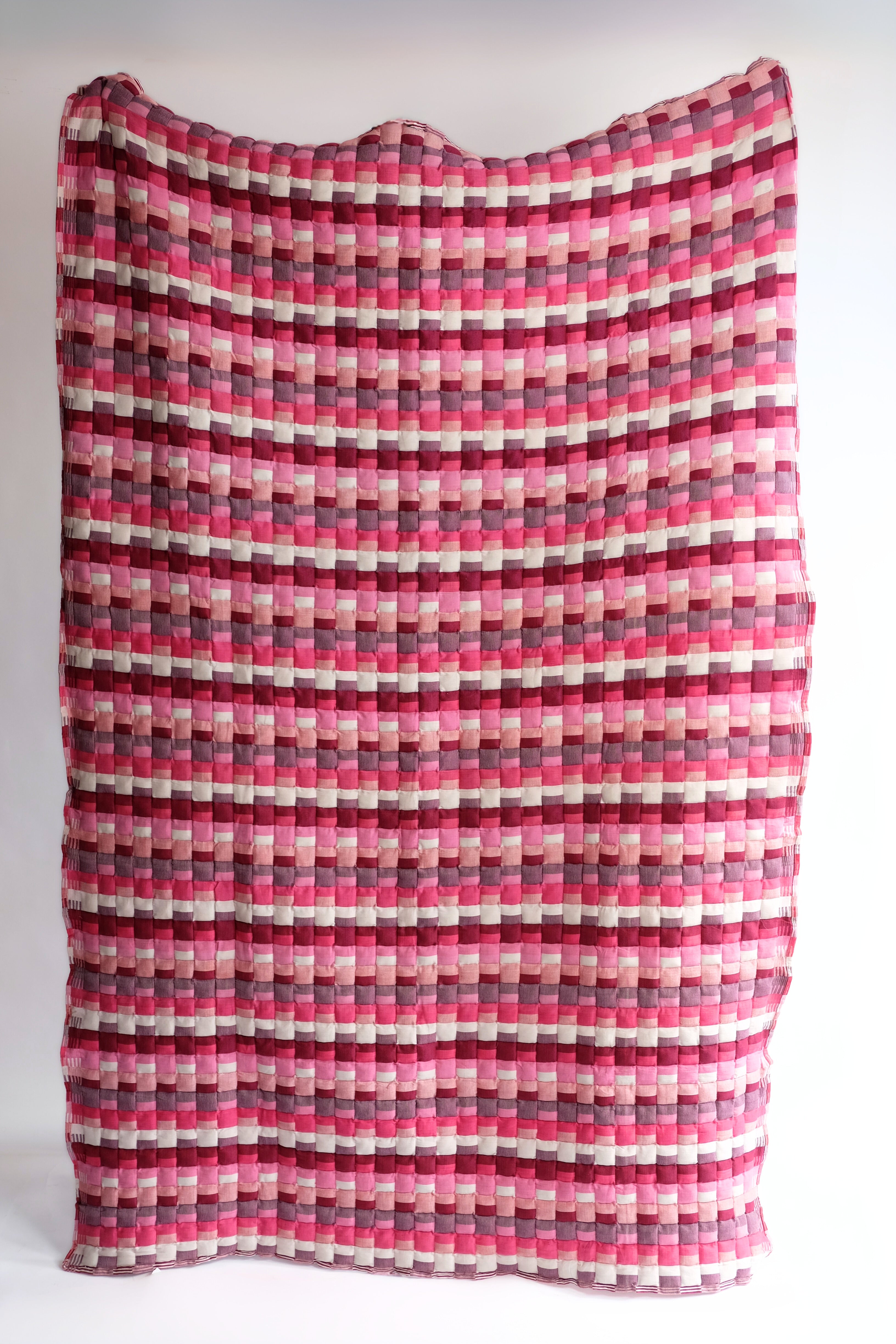 Pink Tetris Sujani quilt with multicolored block patterns, displayed flat
