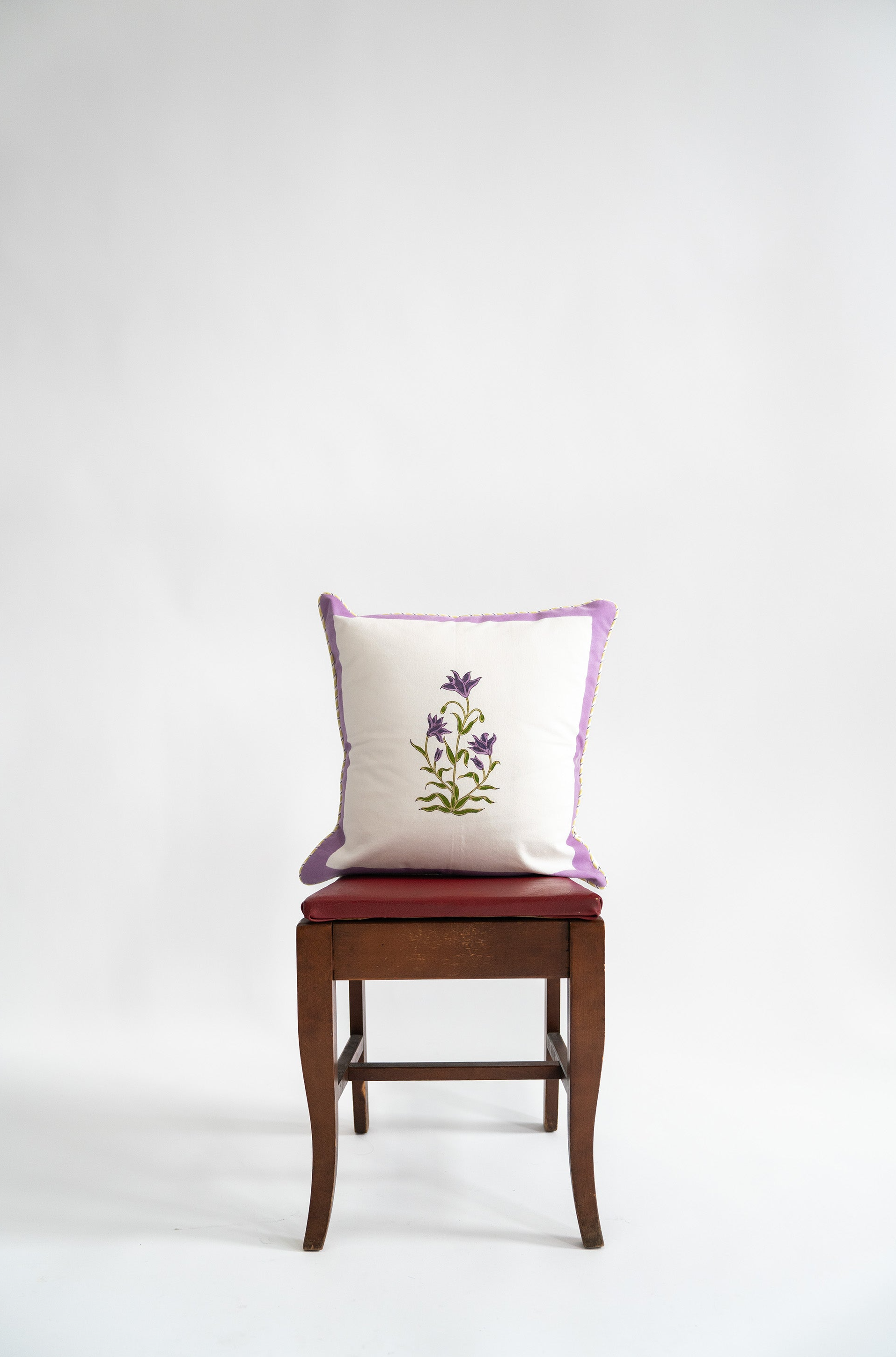 Purple botanical study blockprint pillow on wooden chair