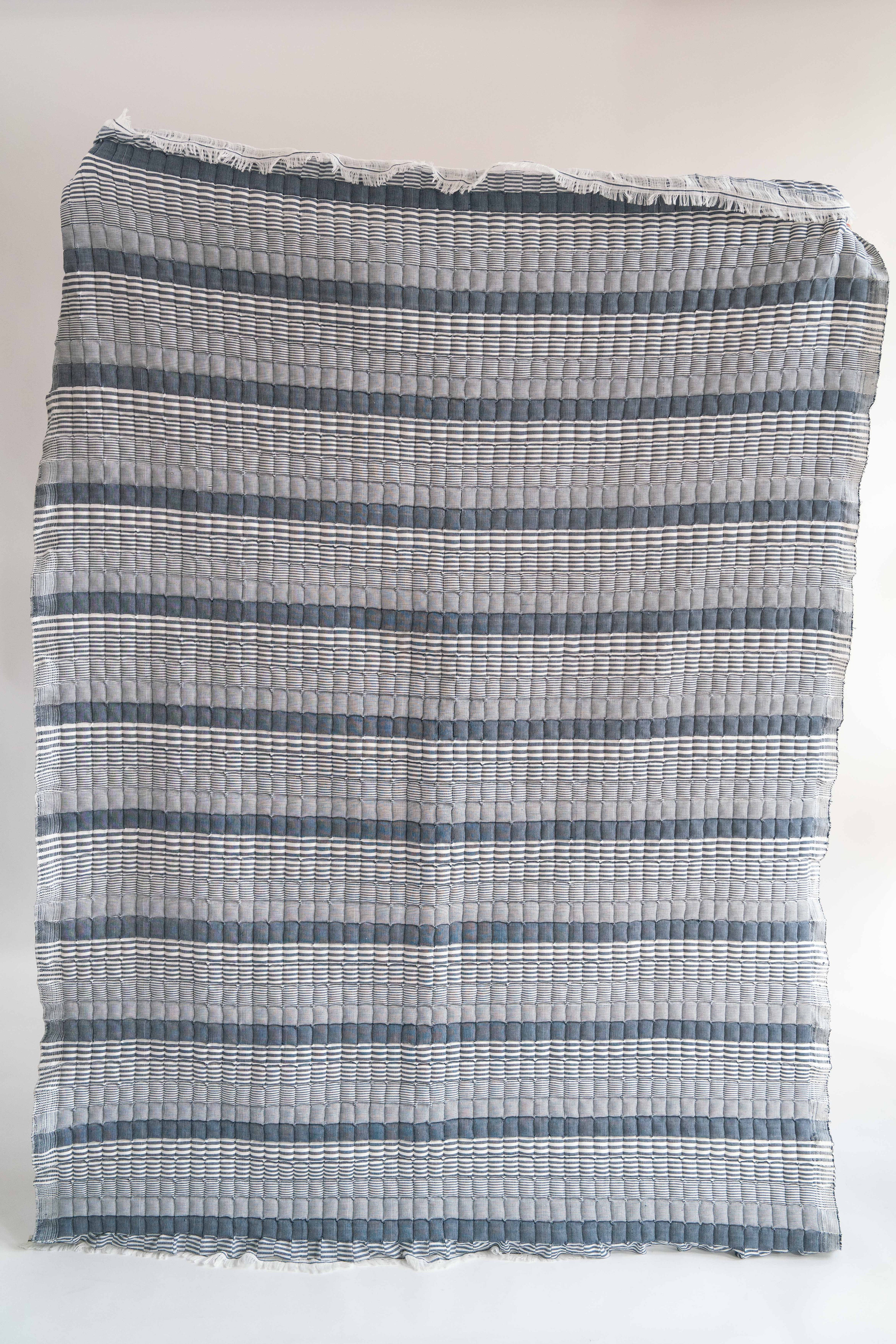 Blue striped Sujani quilt with fringed edges