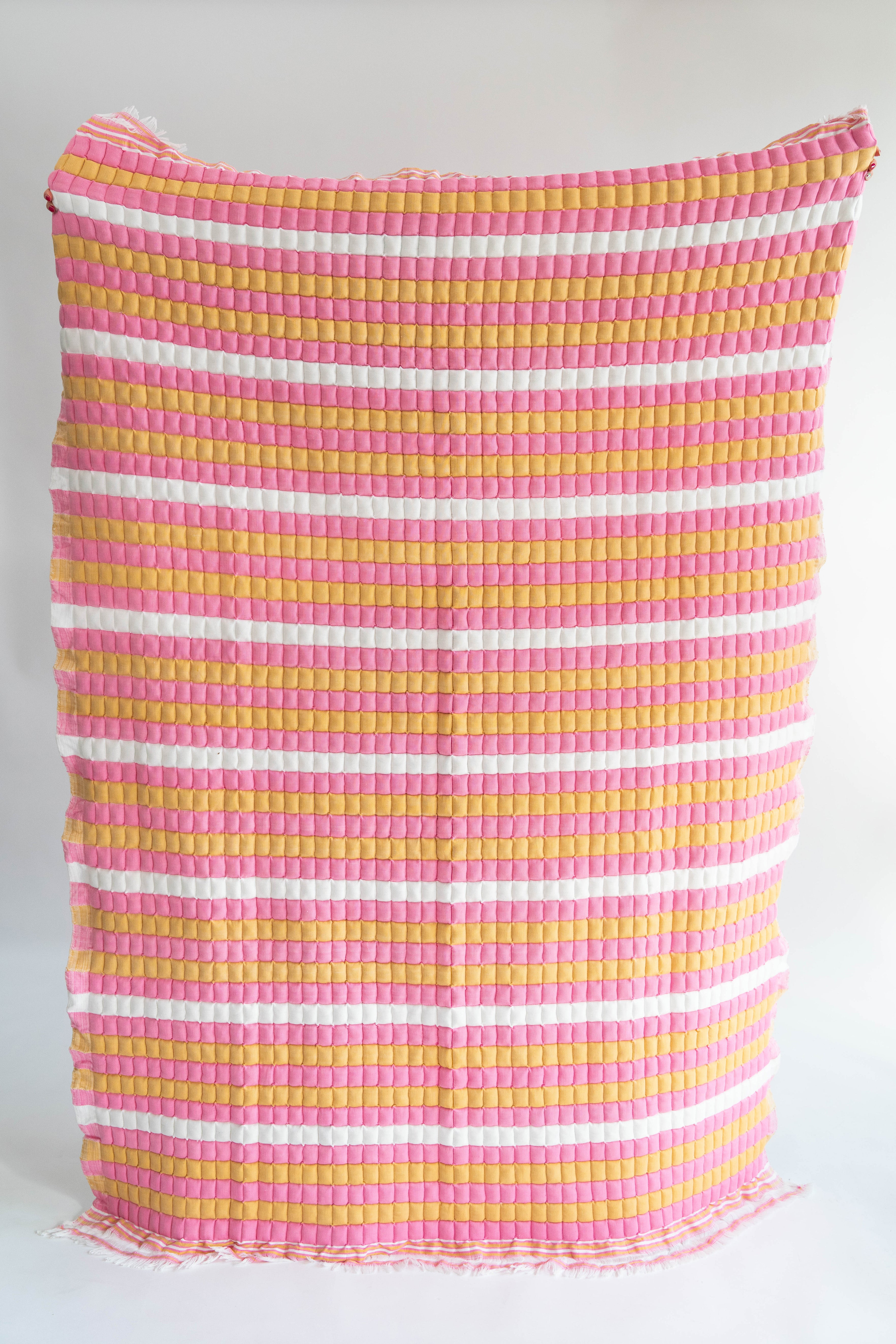Pink, yellow striped sujani quilt with fringed edges, New York design studio