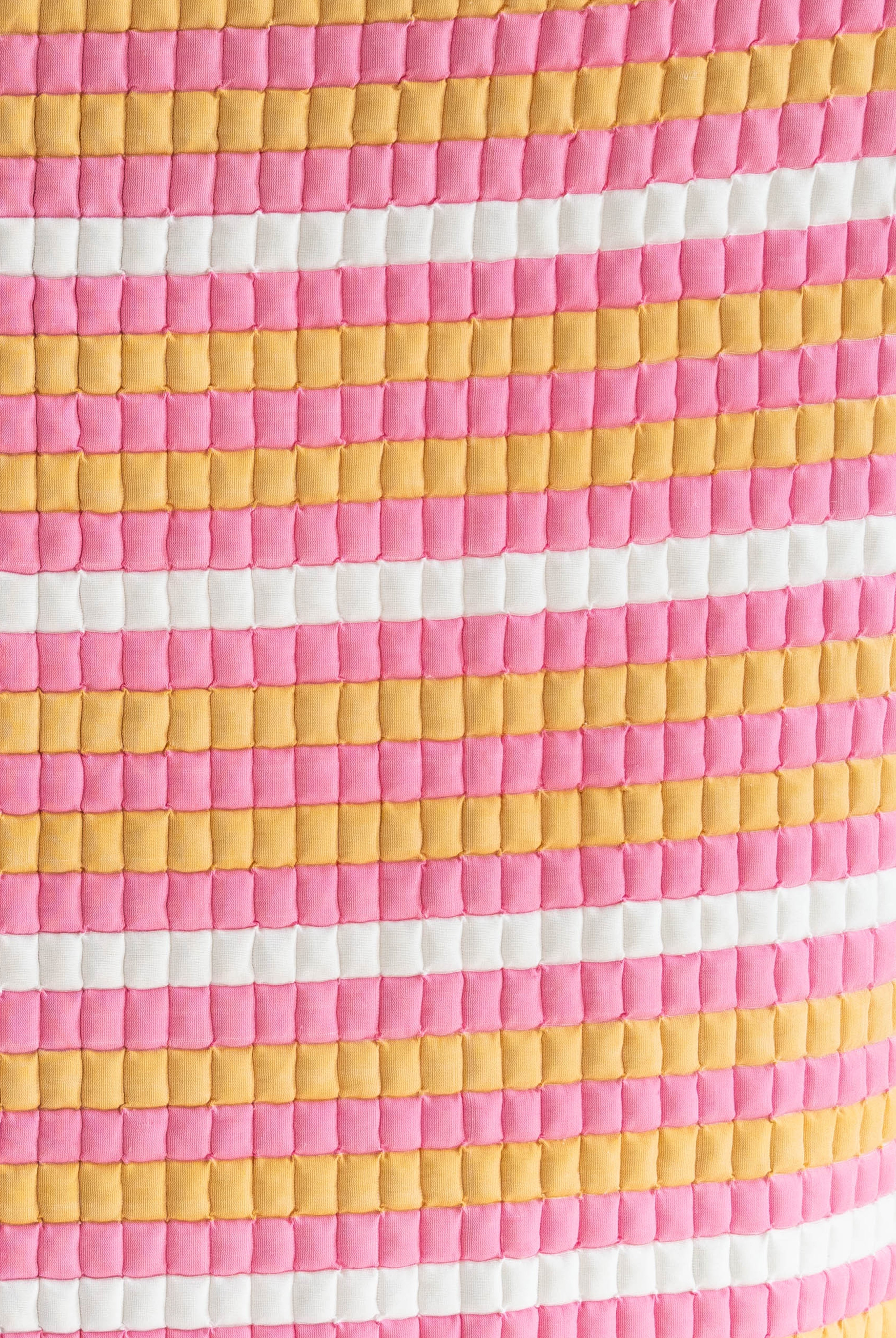 Close-up detail of pink-yellow-white Grand Budapest Sujani quilt fabric