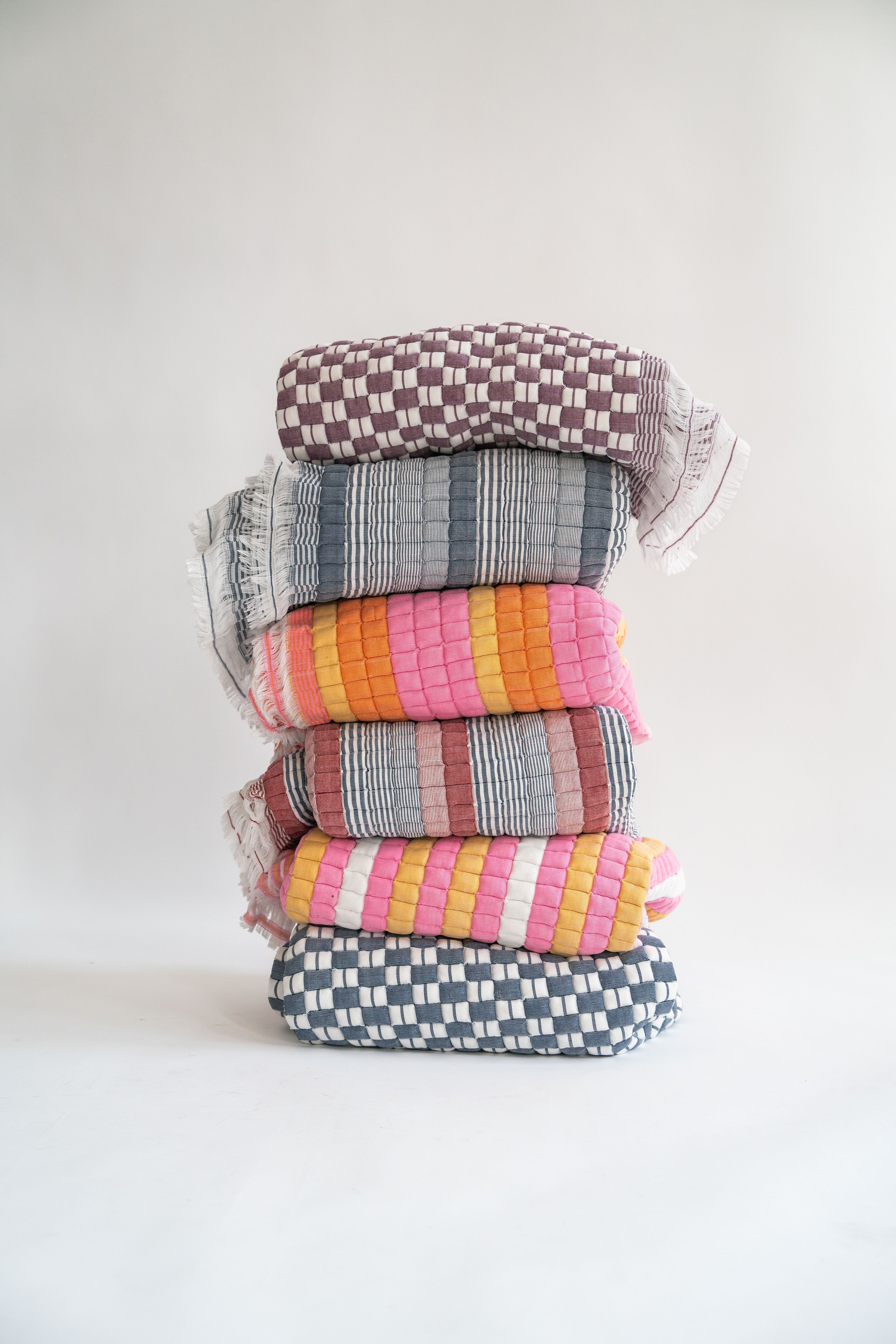 Stacked colorful Grand Budapest Sujani quilts display - Inner Child