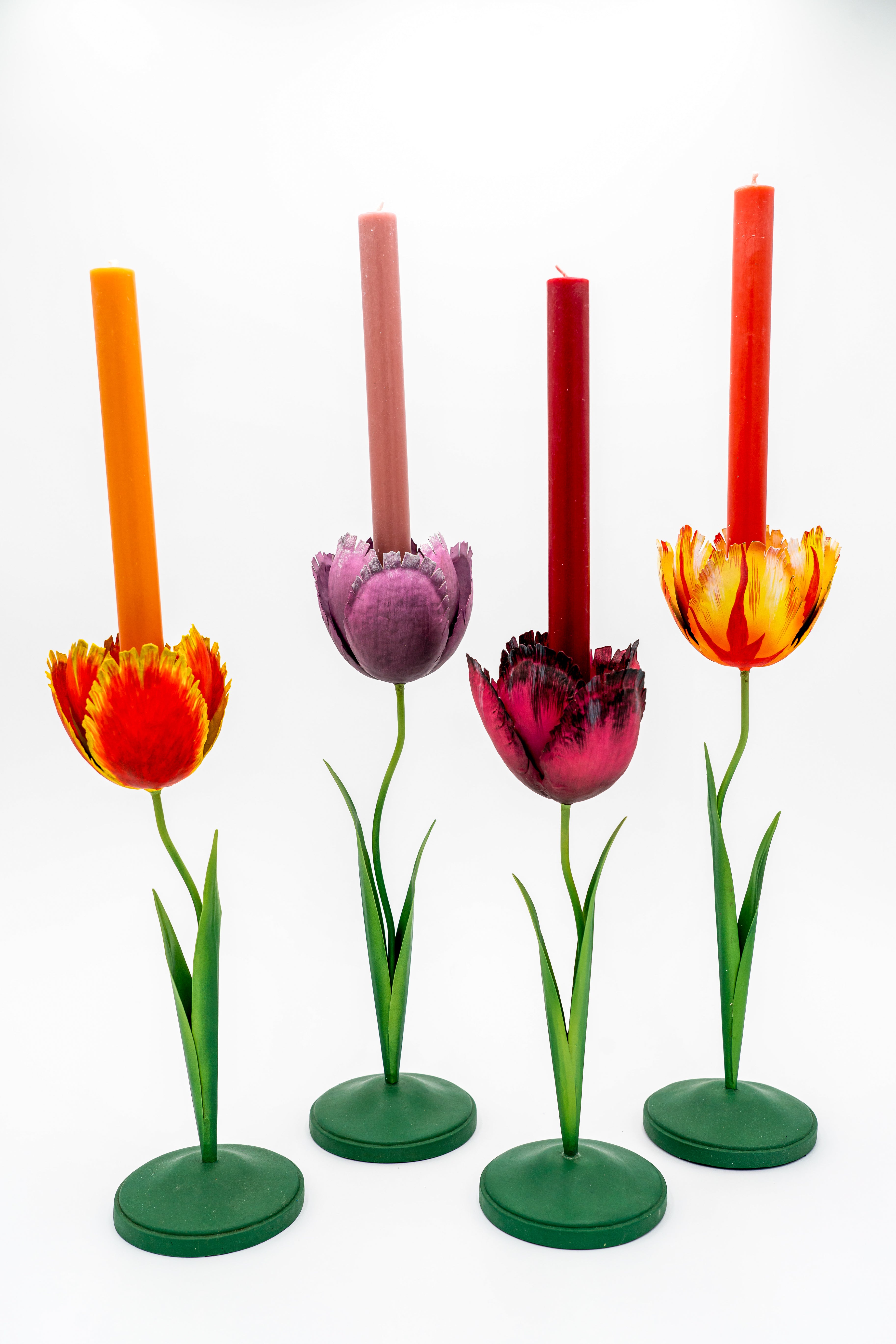Four medium tulip candleholders in varied colors with tall candles