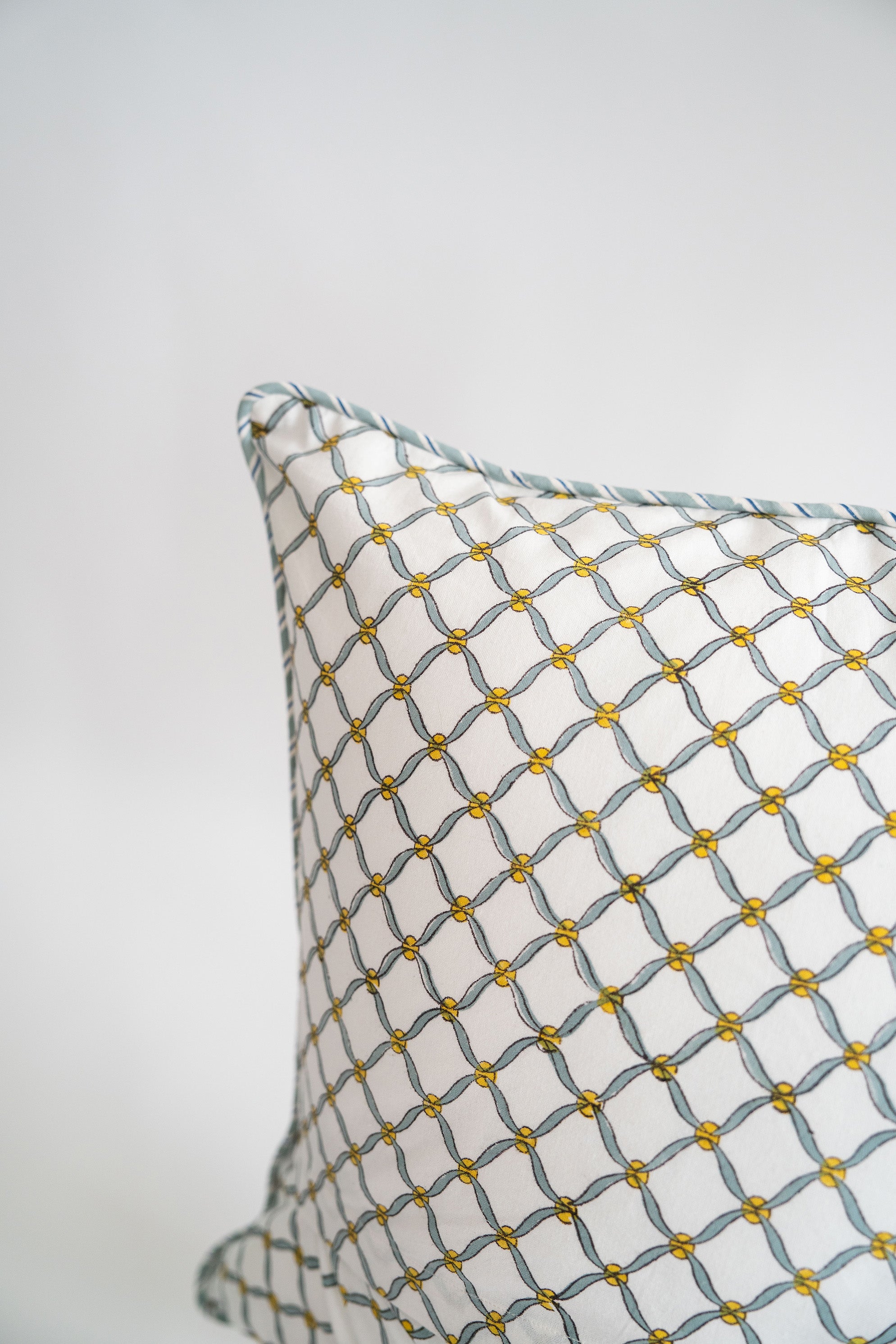 Blue poppy blockprint pillow showcasing geometric pattern with yellow accents