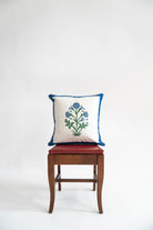 Cobalt-trimmed botanical blockprint pillow on wooden chair