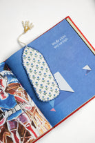 Blue Primrose blockprint bookmark in open book with colorful pages