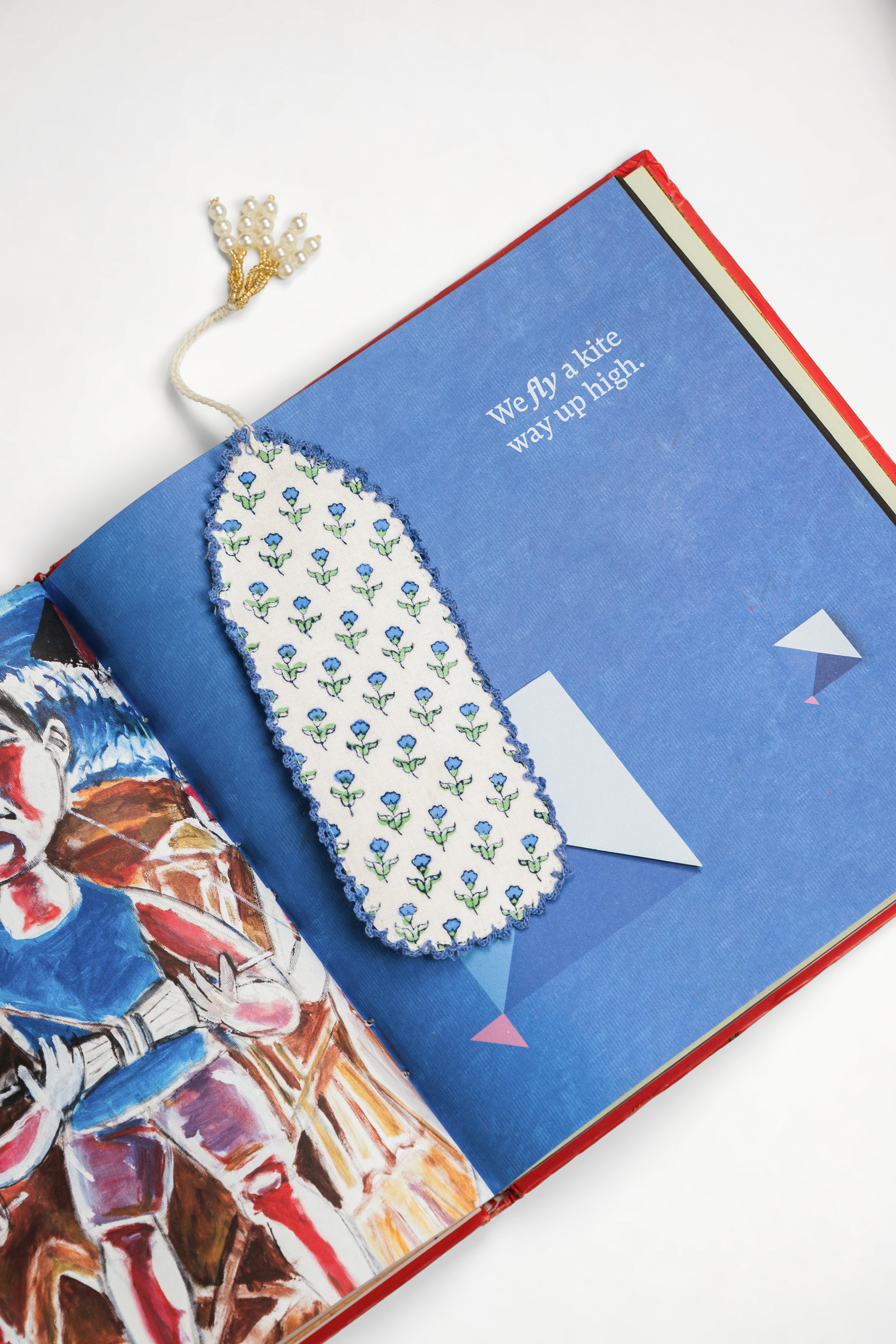 Blue Primrose blockprint bookmark in open book with colorful pages