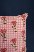 Close-up of square pillow with dahlia flower details on pink gingham fabric