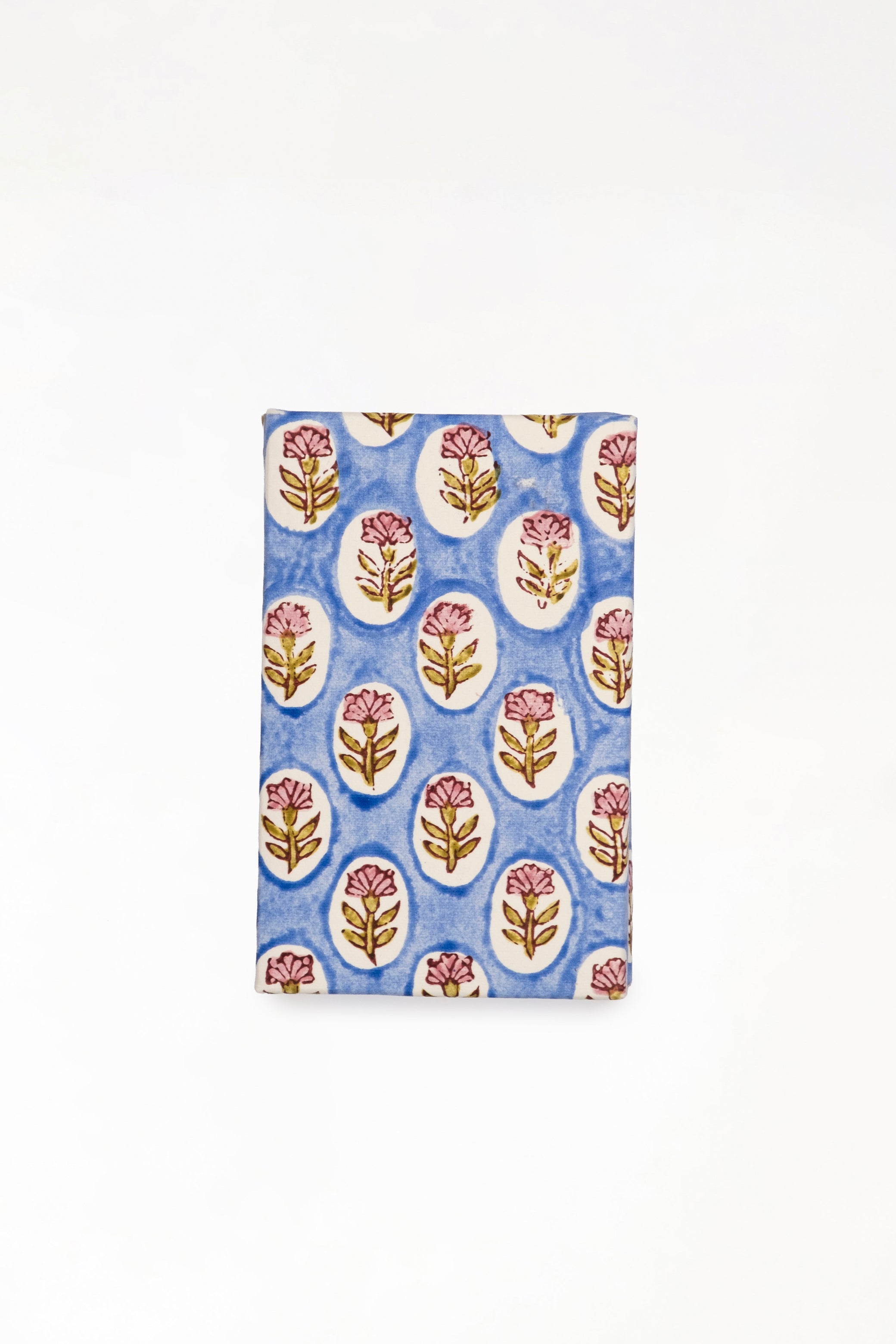 Close-up view of blue daisy blockprint notecard with pink flower patterns