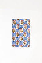 Close-up view of blue daisy blockprint notecard with pink flower patterns