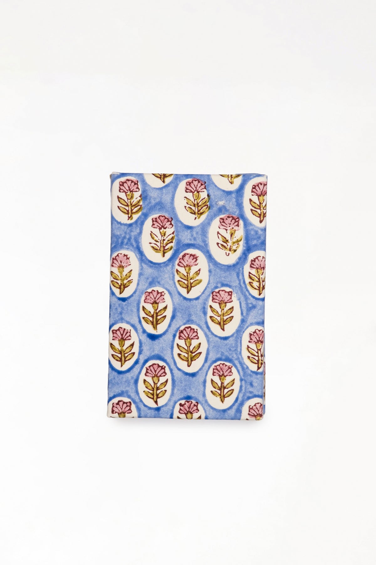 Close-up view of blue daisy blockprint notecard with pink flower patterns
