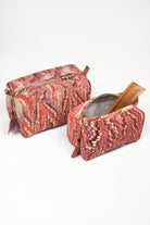 Two florentine pink hand-marbled quilted cosmetic bags, one open with wooden comb