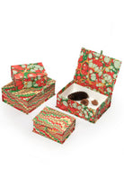 Hand-marbled keepsake box set in Christmas gems pattern with red, green, and white swirls, including open boxes with pinecones and small decorative items.