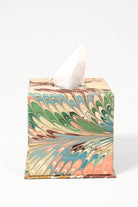 Hand-marbled tissue box cover with Flatiron Feathers pattern in green, pink, blue, and beige, with a tissue partially pulled out.