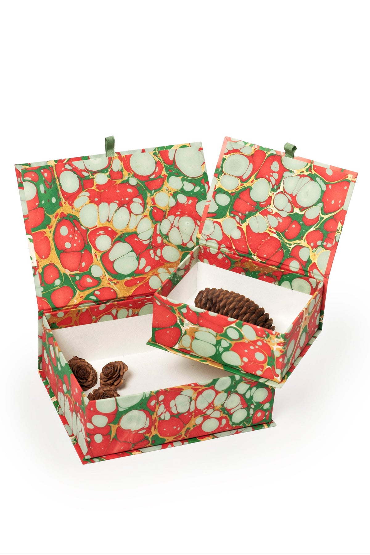 Hand-marbled keepsake box set in Christmas gems pattern with red, green, and white swirls, featuring open boxes with pinecones and small decorative items inside.