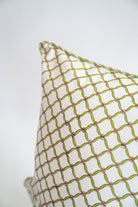 White decorative pillow with green and pink blockprint geometric pattern