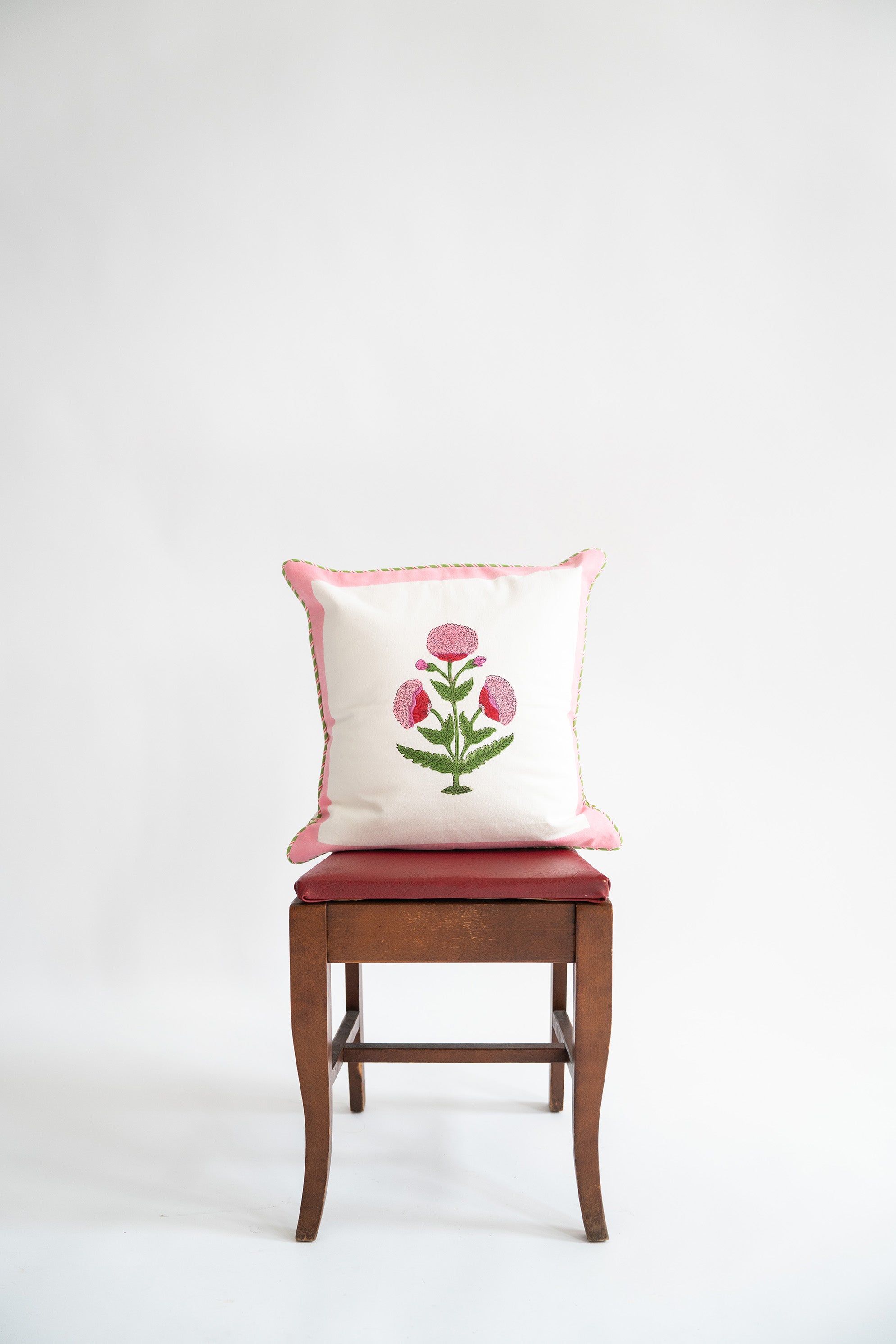 Pink poppy blockprint decorative pillow on wooden chair