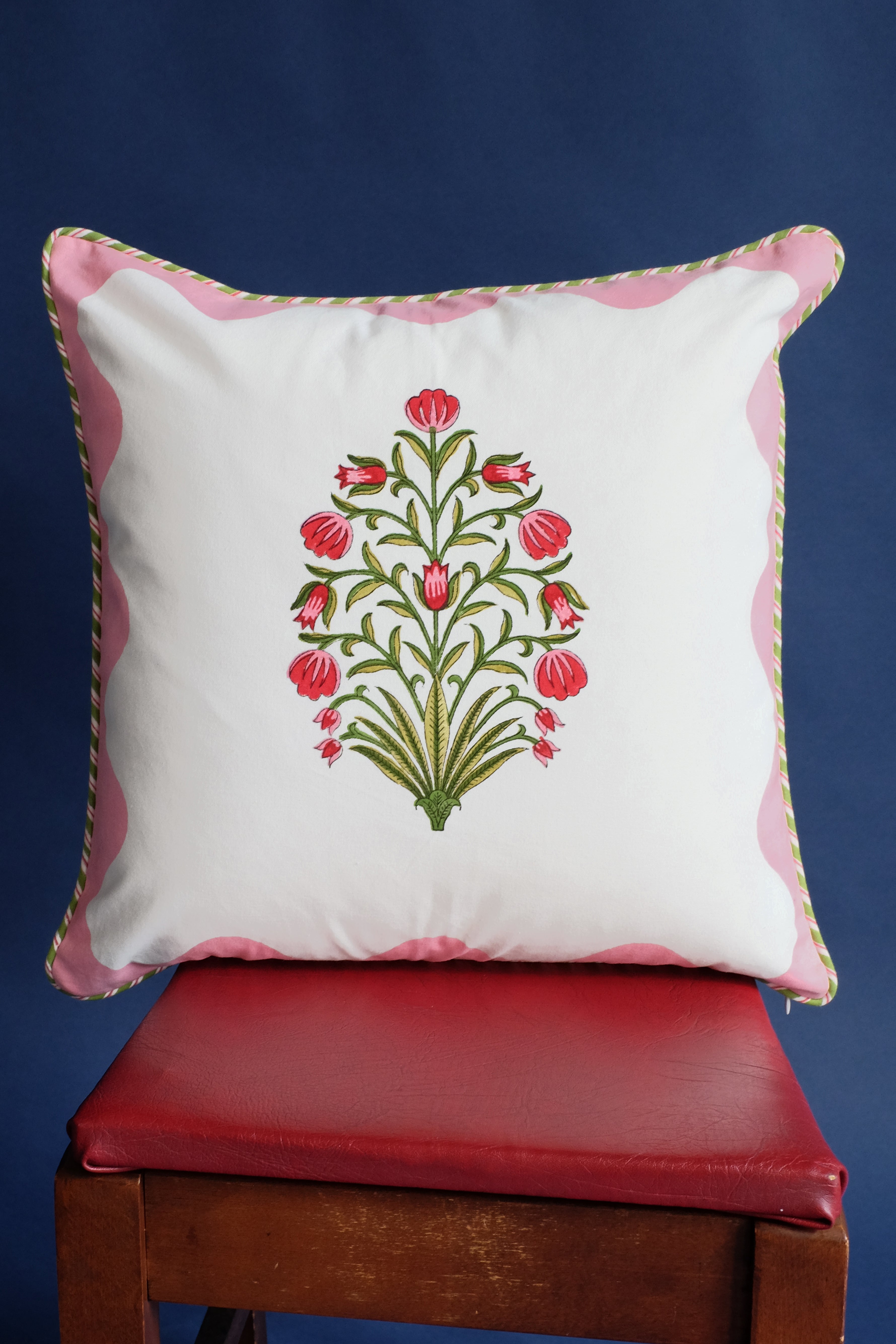 Pink scallop-floral blockprint throw pillow on red chair - Inner Child