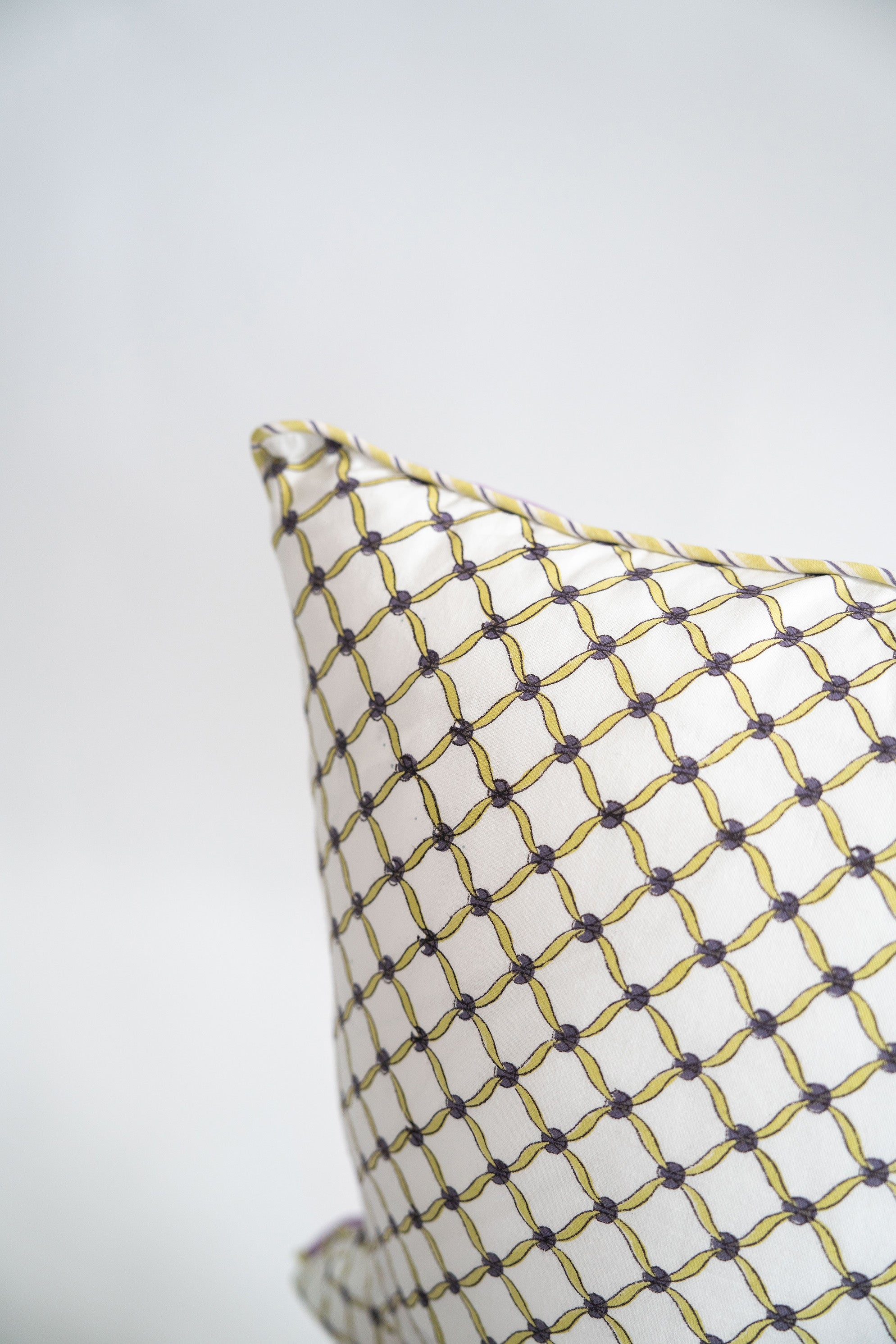 Yellow and gray geometric patterned decorative pillow detail