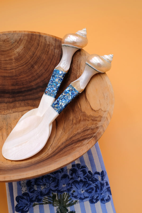 Blue seashell serving spoons with pearl tops and blue shell inlays on wooden bowl